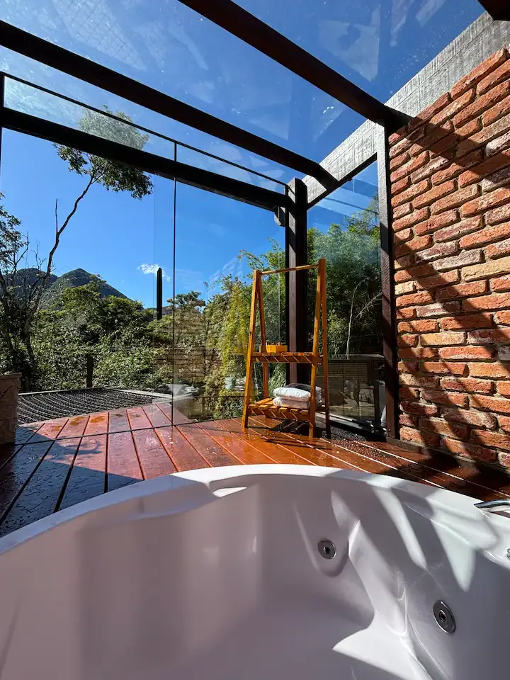 Hidromassagem em primeiro plano, com o deck de madeira e a vista atrás