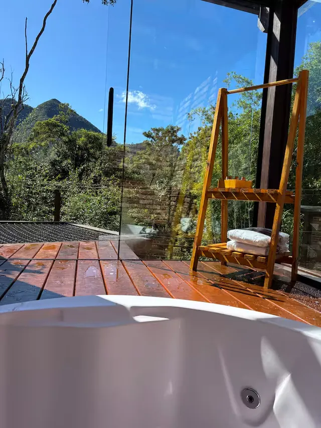 Hidromassagem no deck de madeira com vista para o vale