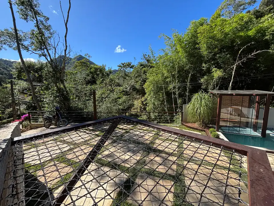 Rede armada no gramado do Chalé Bougainville, com a piscina ao fundo