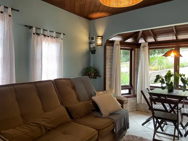 Sala da Casa Verde, com sofá, mesa de jantar e janelas amplas