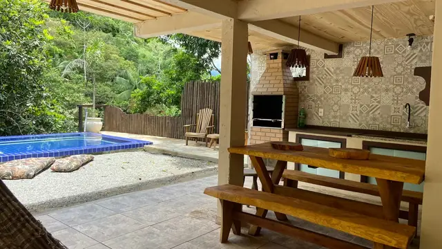 Área gourmet com churrasqueira e lavabo, ao lado da piscina